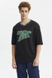 Polera negra slim para hombre con texto Michigan State en el pecho en verde y blanco estilo universitario
