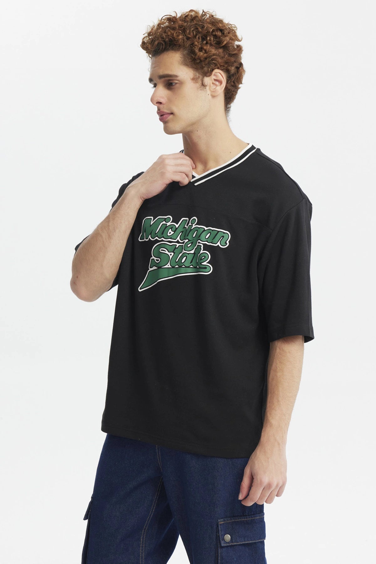 Polera negra slim para hombre con texto Michigan State en el pecho en verde y blanco estilo universitario