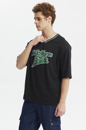 Polera negra slim para hombre con texto Michigan State en el pecho en verde y blanco estilo universitario