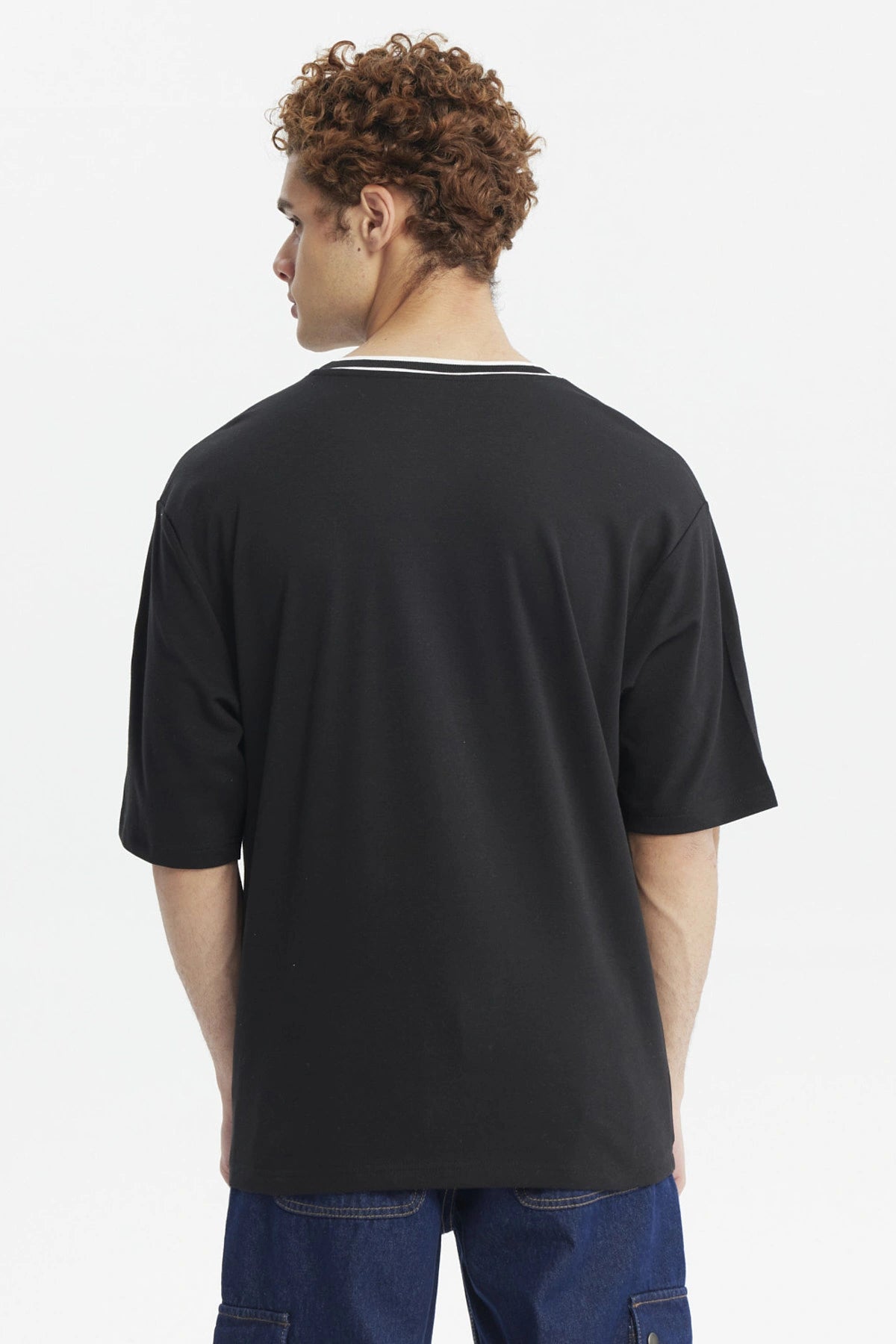 Polera negra slim para hombre con texto Michigan State en el pecho en verde y blanco estilo universitario