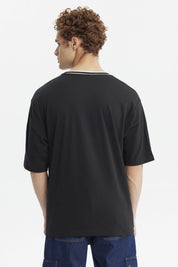 Polera negra slim para hombre con texto Michigan State en el pecho en verde y blanco estilo universitario