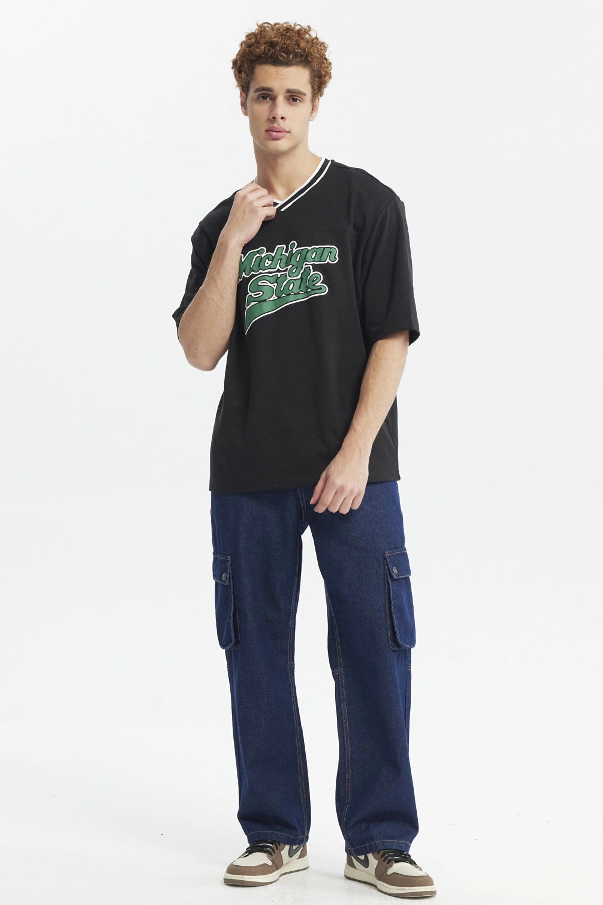 Polera negra slim para hombre con texto Michigan State en el pecho en verde y blanco estilo universitario