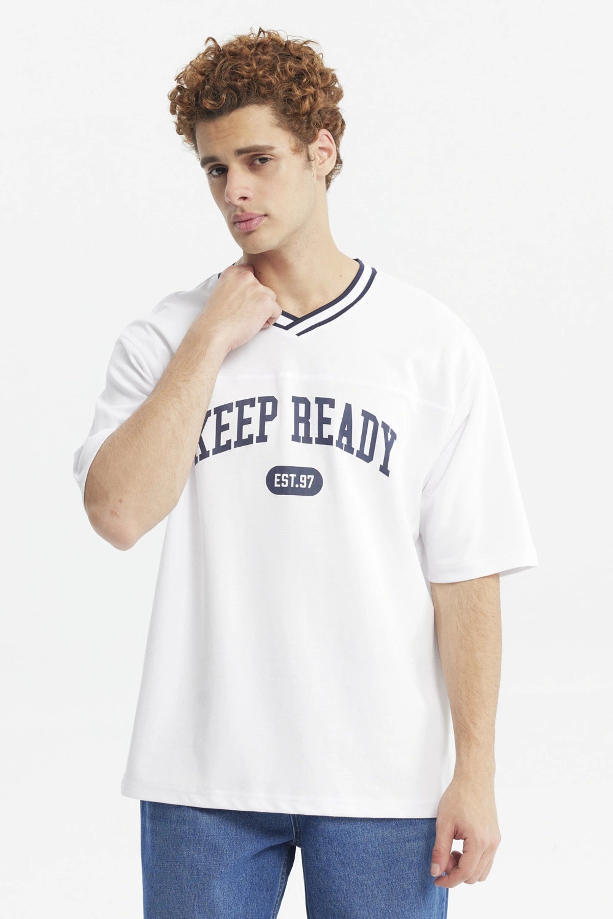 Polera slim blanca para hombre con texto KEEP READY EST 97 en el pecho estilo casual urbano y cuello en V con ribete negro