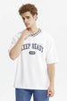 Polera slim blanca para hombre con texto KEEP READY EST 97 en el pecho estilo casual urbano y cuello en V con ribete negro