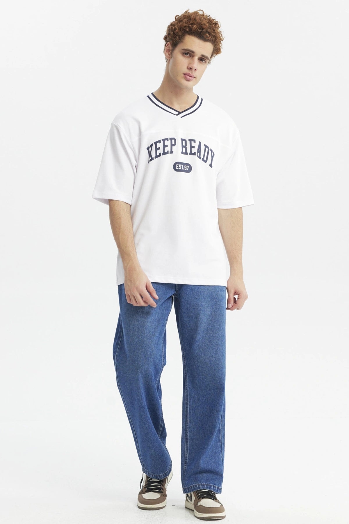 Polera slim blanca para hombre con texto KEEP READY EST 97 en el pecho estilo casual urbano y cuello en V con ribete negro