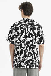 Camisa negra de hombre con estampado geométrico blanco abstracto en toda la prenda de manga corta