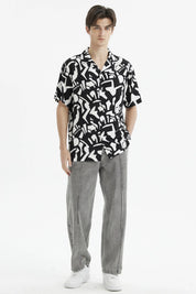 Camisa negra de hombre con estampado geométrico blanco abstracto en toda la prenda de manga corta