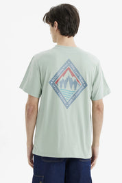 Polera hombre verde claro con diseño de montañas en el pecho estilo minimalista y gráfico pequeño a la izquierda