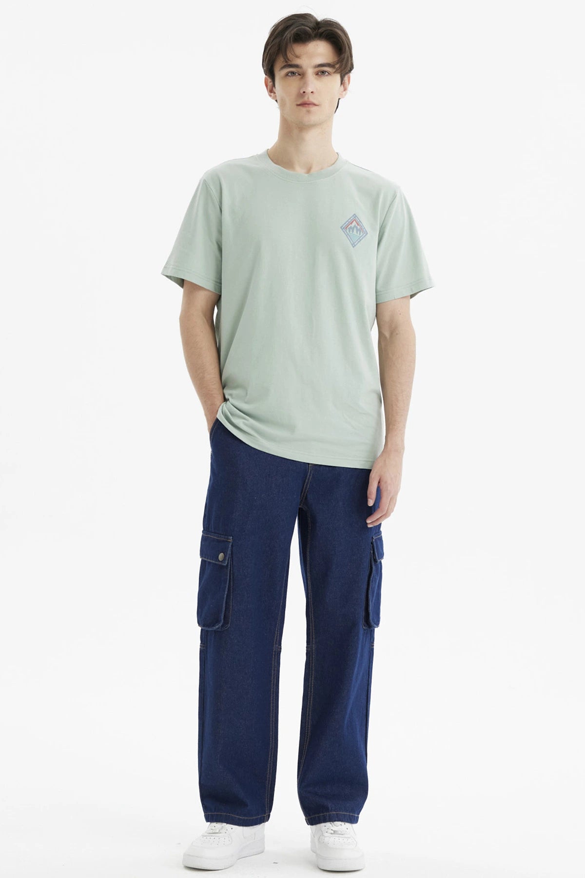 Polera hombre verde claro con diseño de montañas en el pecho estilo minimalista y gráfico pequeño a la izquierda