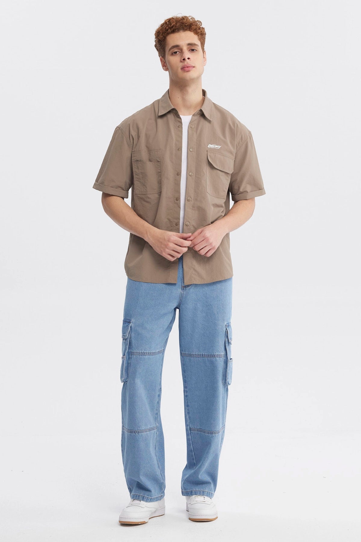 Camisa oversize café de hombre con doble bolsillo y texto pequeño en el pecho estilo casual y relajado