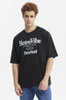 Polera negra oversize de hombre con estampado RetroVibe en letras grandes al frente estilo urbano