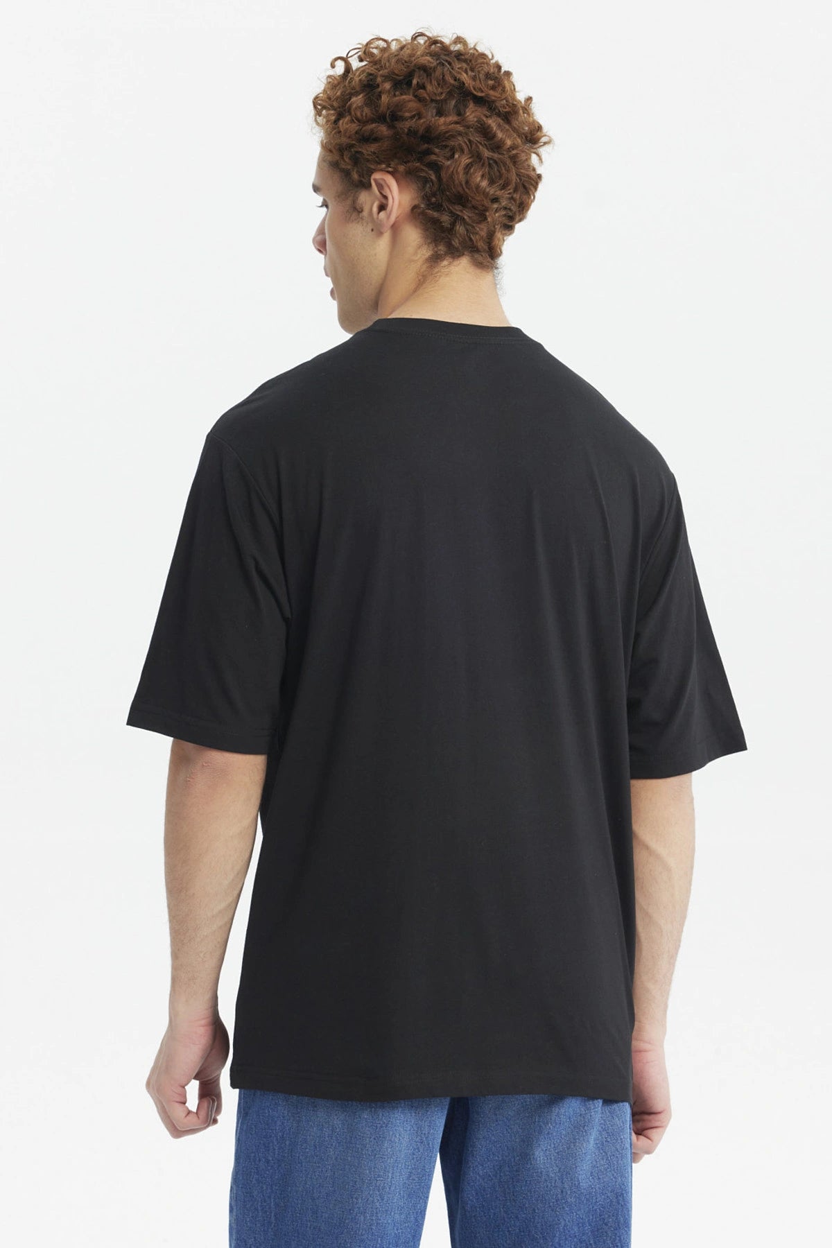 Polera negra oversize de hombre con estampado RetroVibe en letras grandes al frente estilo urbano