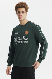 Polerón oversize verde con estampado blanco en el pecho y detalle de escudo en el lado izquierdo estilo deportivo