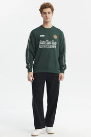Polerón oversize verde con estampado blanco en el pecho y detalle de escudo en el lado izquierdo estilo deportivo