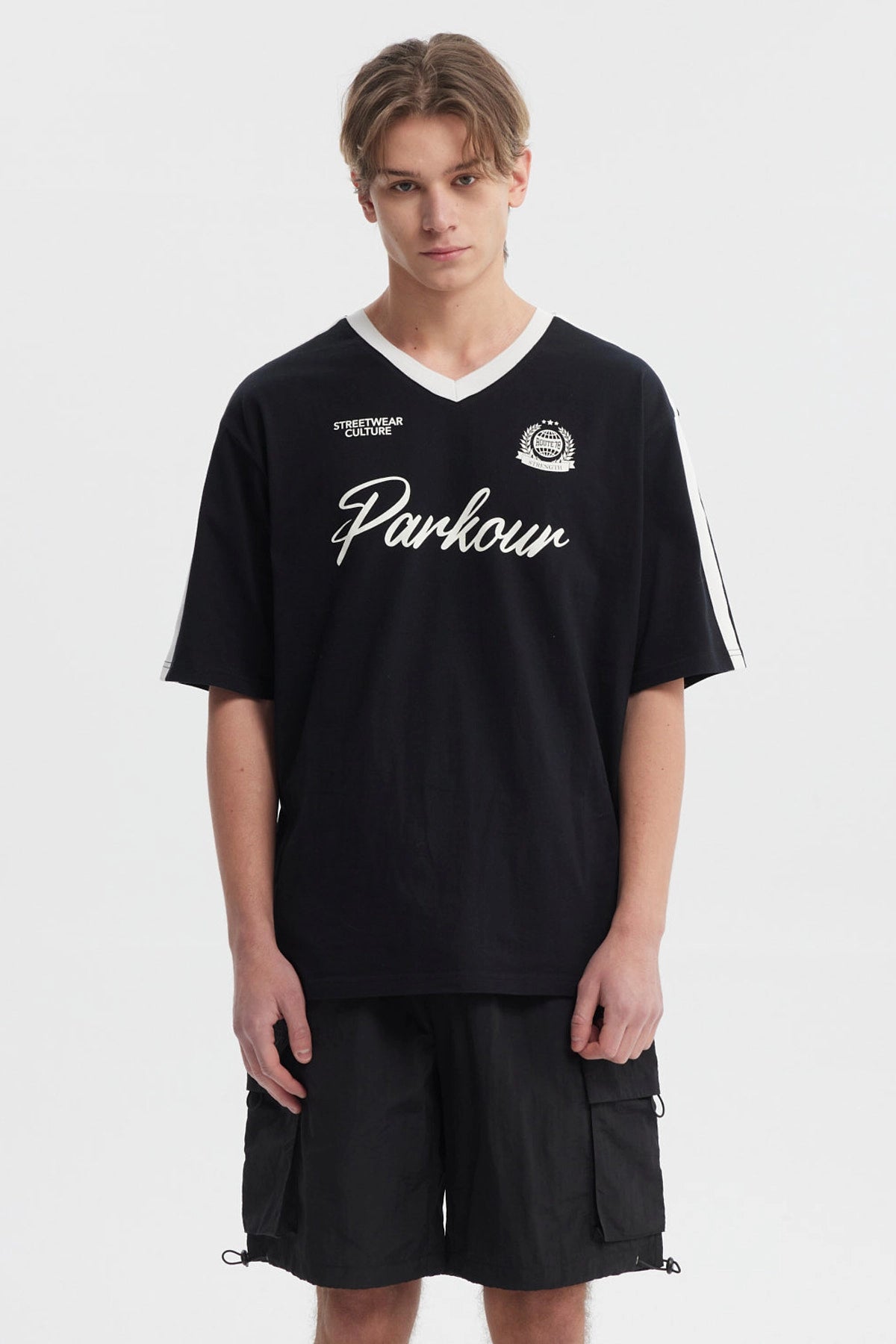 Polera oversize negra para hombre con cuello en V blanco y texto Parkour en el pecho estilo deportivo sin estampa adicional