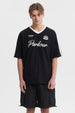 Polera oversize negra para hombre con cuello en V blanco y texto Parkour en el pecho estilo deportivo sin estampa adicional