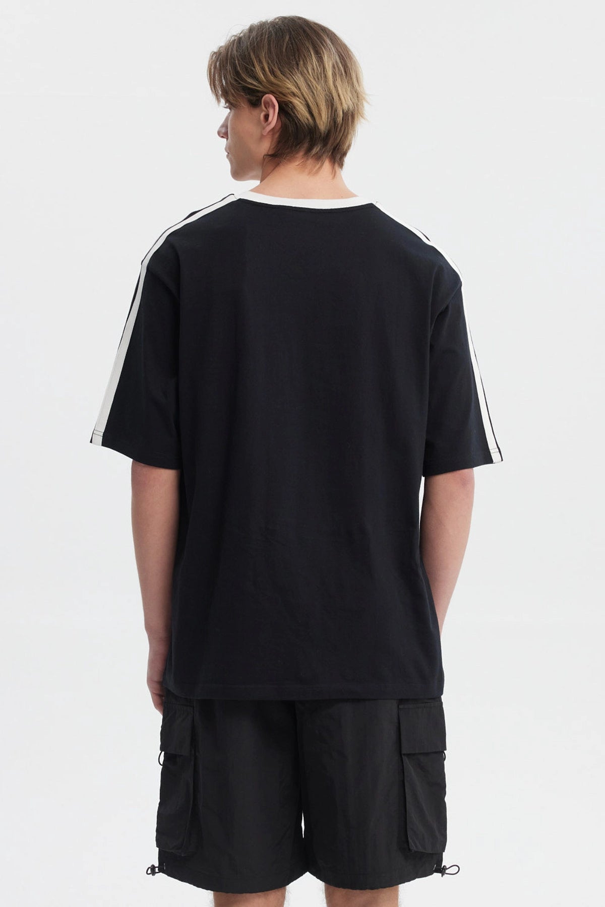 Polera oversize negra para hombre con cuello en V blanco y texto Parkour en el pecho estilo deportivo sin estampa adicional
