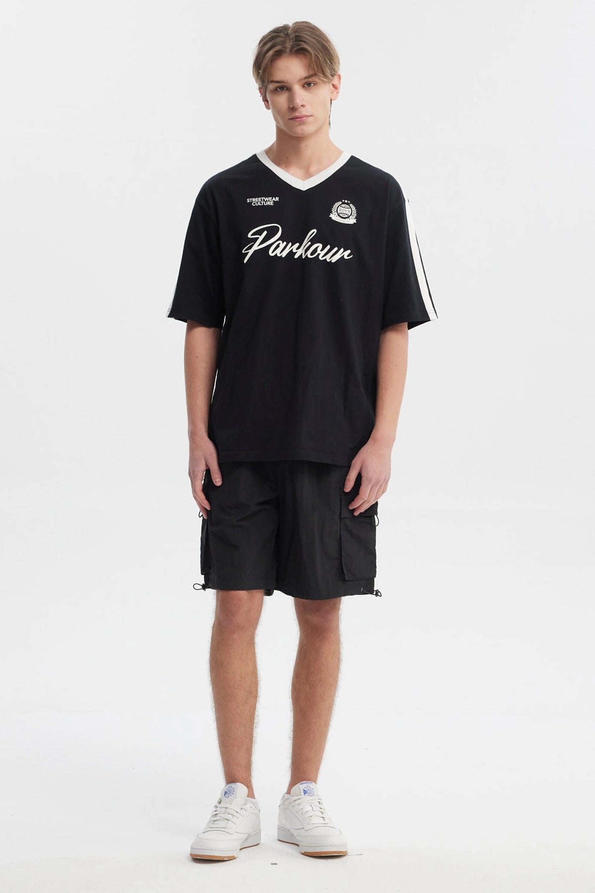 Polera oversize negra para hombre con cuello en V blanco y texto Parkour en el pecho estilo deportivo sin estampa adicional