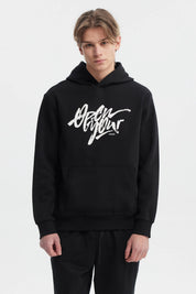 Polerón negro hombre con capucha y texto graffiti blanco al frente estilo urbano relajado