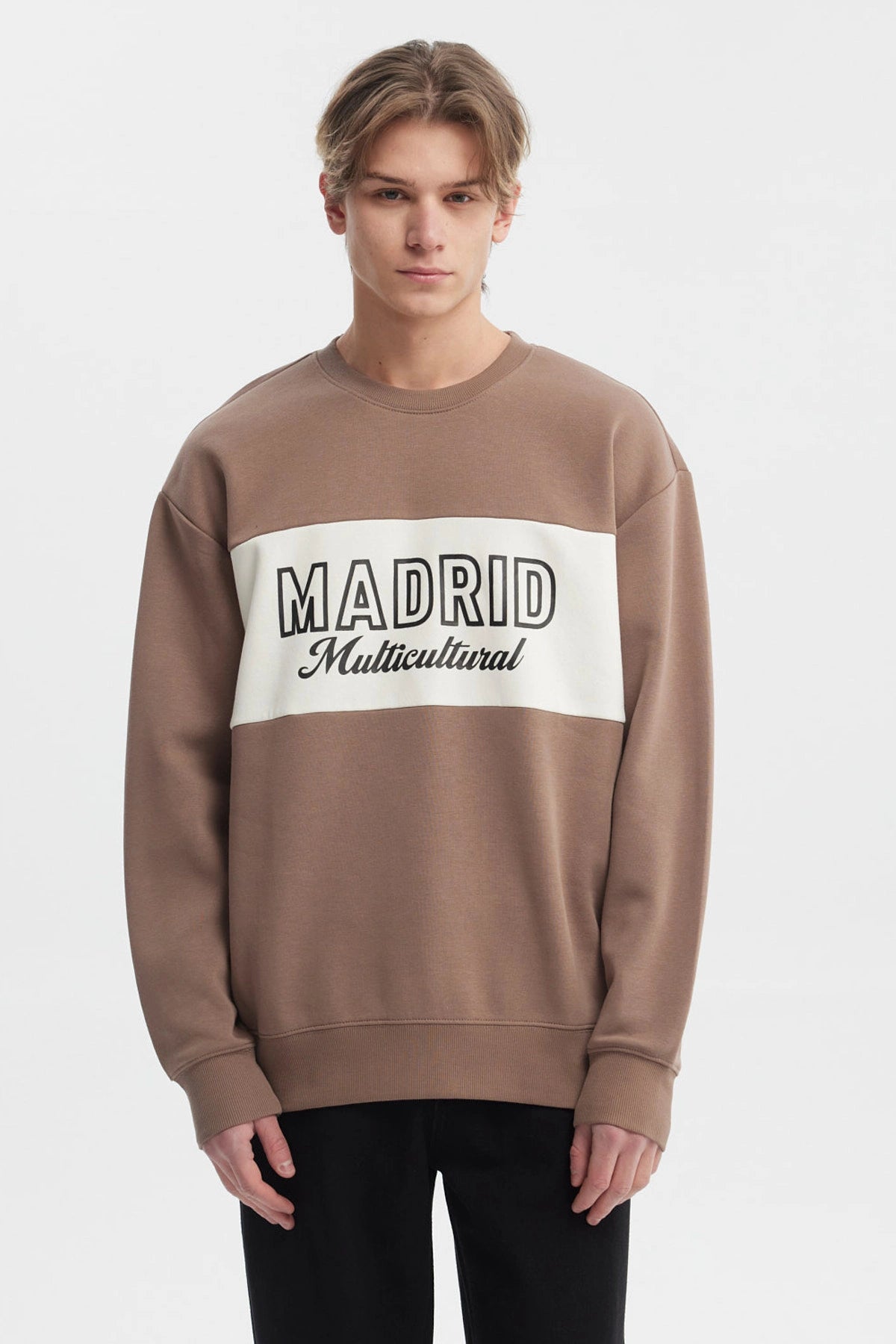 Polerón oversize kaki con cuello redondo y texto 'Madrid Multicultural' en el pecho estilo casual moderno