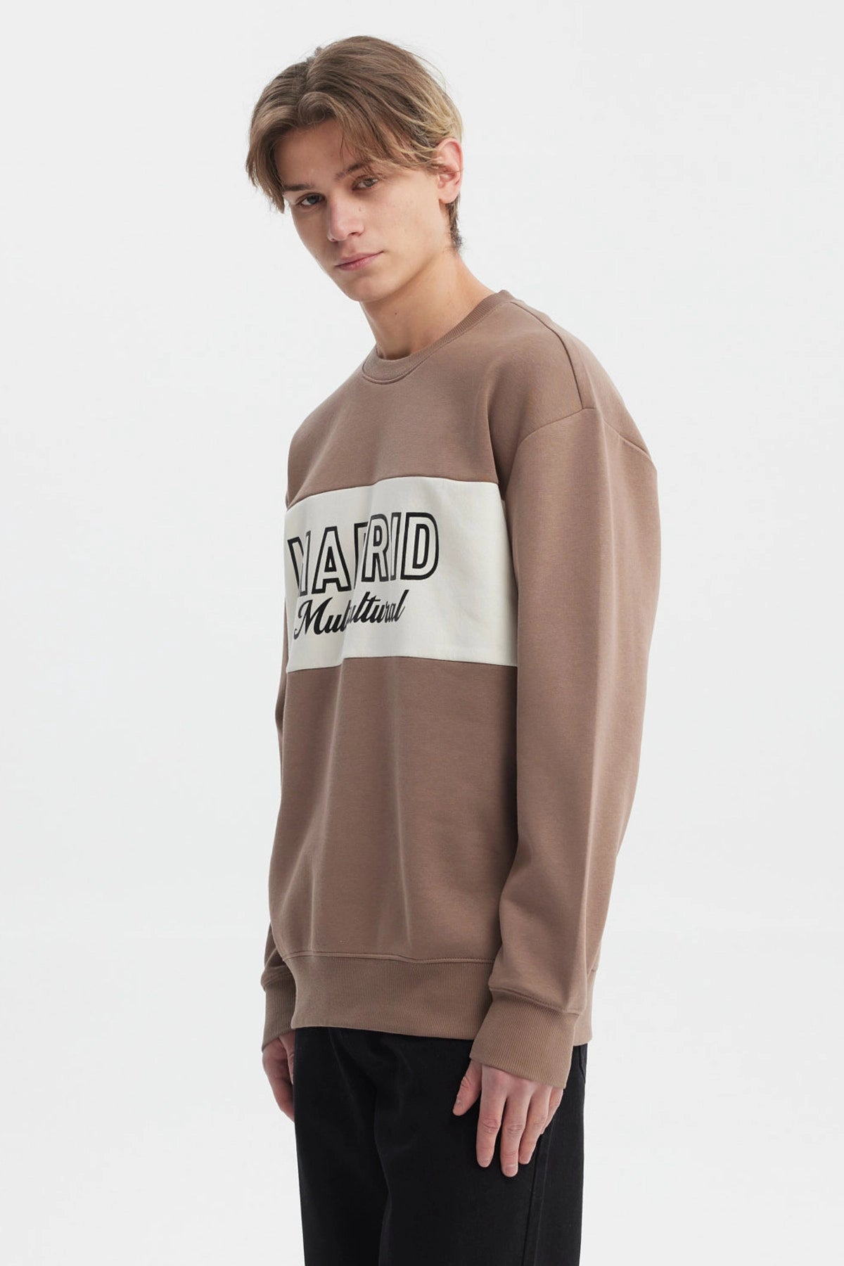 Polerón oversize kaki con cuello redondo y texto 'Madrid Multicultural' en el pecho estilo casual moderno