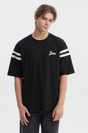Polera oversize negra para hombre con texto Ability en el pecho y rayas blancas en mangas estilo casual