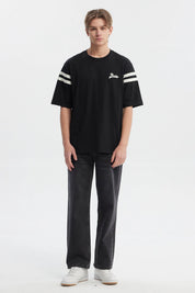 Polera oversize negra para hombre con texto Ability en el pecho y rayas blancas en mangas estilo casual