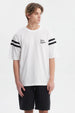 Polera oversize blanca con texto Good Fortune en el pecho rayas negras en las mangas estilo casual y moderno