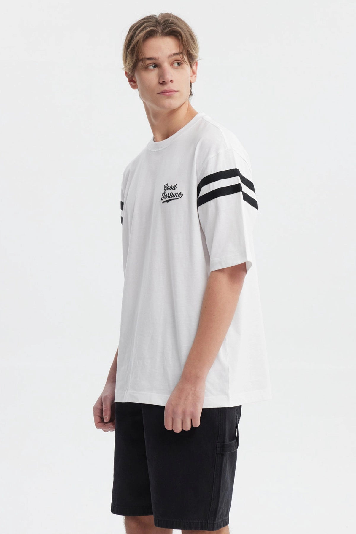 Polera oversize blanca con texto Good Fortune en el pecho rayas negras en las mangas estilo casual y moderno