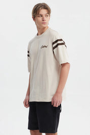 Polera oversize beige con logo "Critical" en el pecho estilo urbano y rayas marrones en las mangas