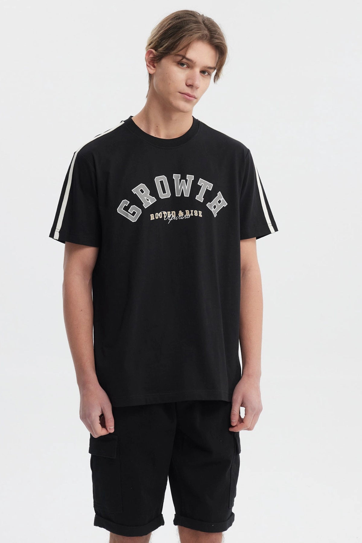Polera negra slim para hombre con texto Growth Move and Rise en el pecho estilo universitario y líneas blancas en los hombros