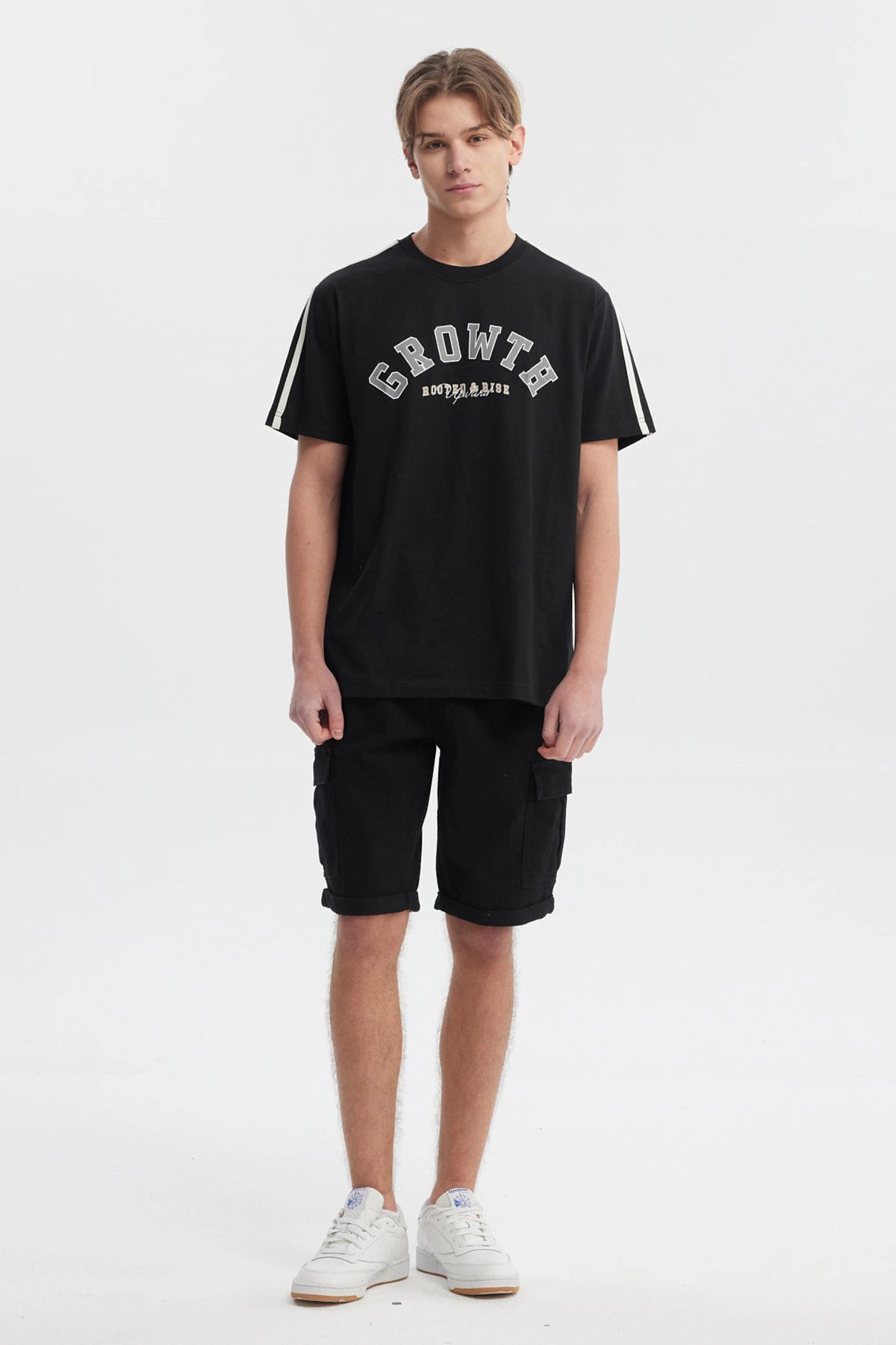 Polera negra slim para hombre con texto Growth Move and Rise en el pecho estilo universitario y líneas blancas en los hombros