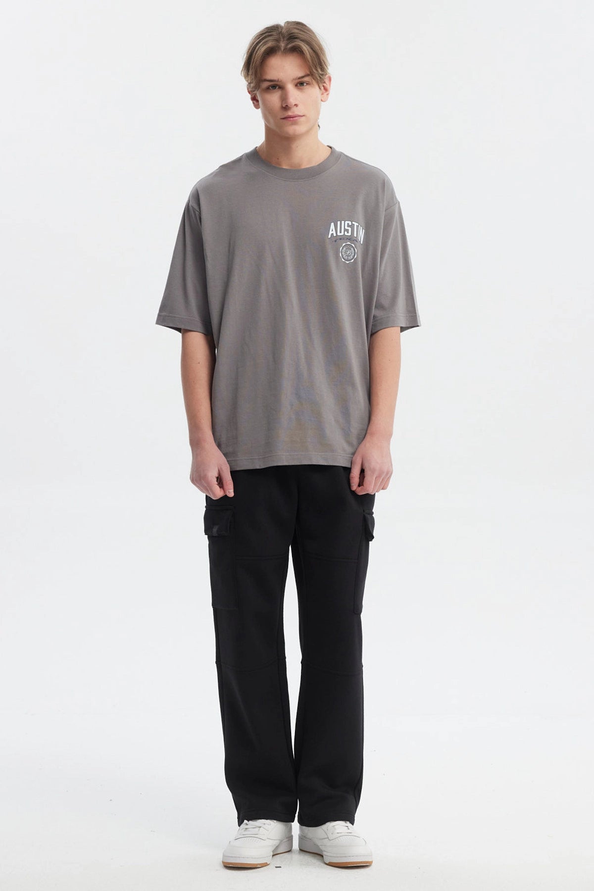Polera hombre slim gris con estampa frontal de texto AUSTIN y escudo pequeño estilo casual