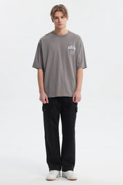 Polera hombre slim gris con estampa frontal de texto AUSTIN y escudo pequeño estilo casual
