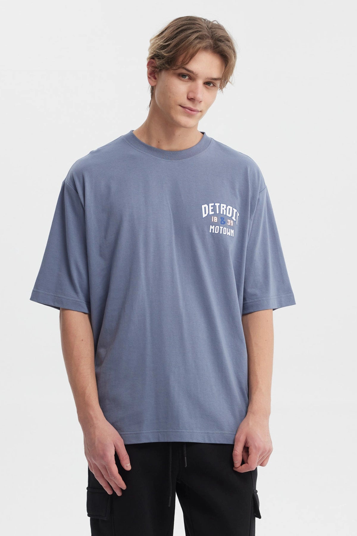 Polera hombre slim azul piedra con texto blanco Detroit 1839 Motown en el pecho estilo casual moderno sin estampa adicional