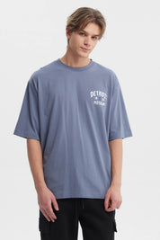 Polera hombre slim azul piedra con texto blanco Detroit 1839 Motown en el pecho estilo casual moderno sin estampa adicional