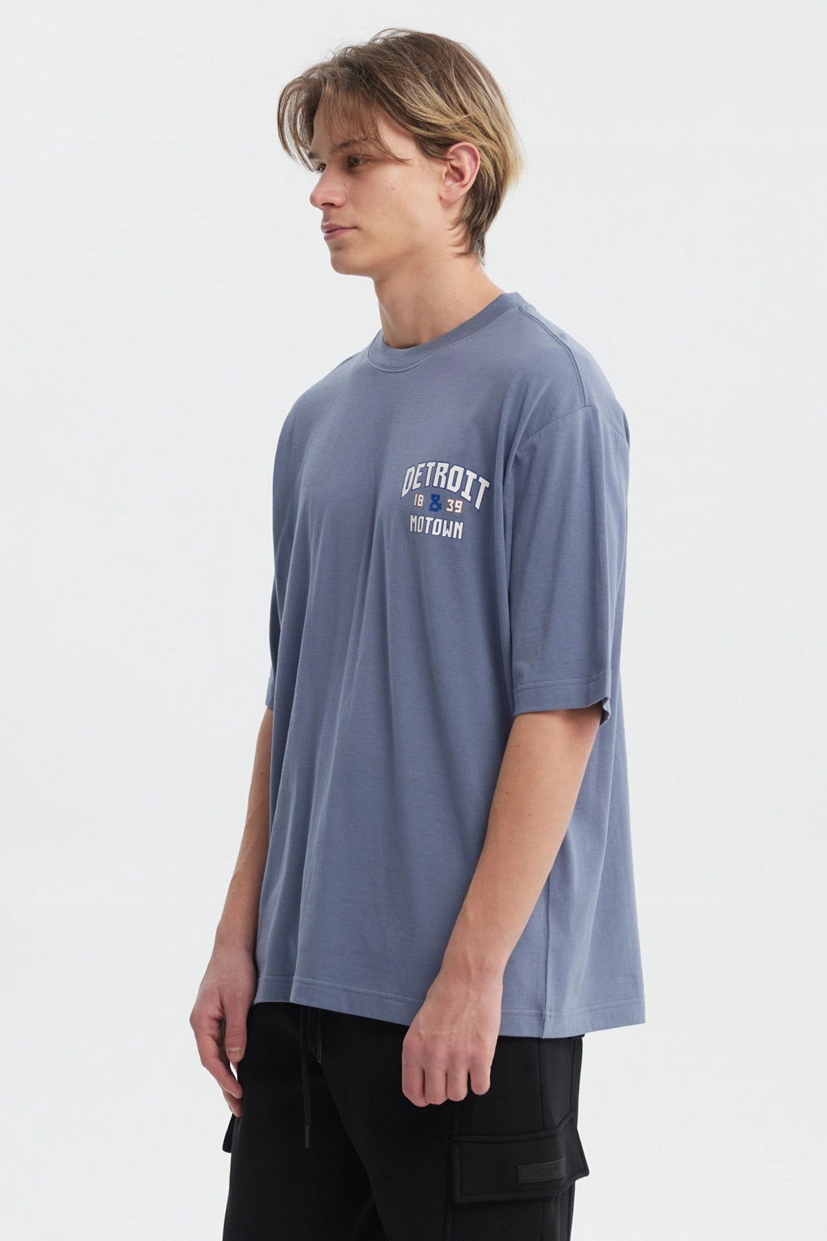 Polera hombre slim azul piedra con texto blanco Detroit 1839 Motown en el pecho estilo casual moderno sin estampa adicional