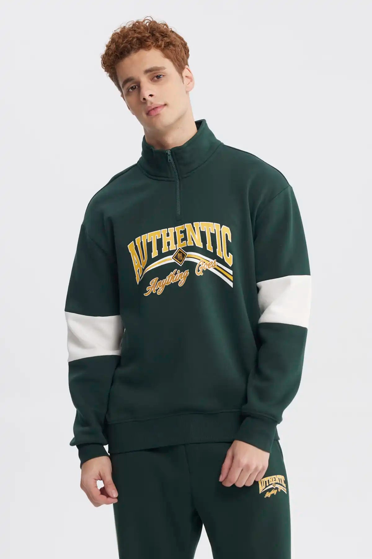 Polerón oversize verde con half zipper y texto Authentic en el pecho estilo universitario en amarillo y blanco