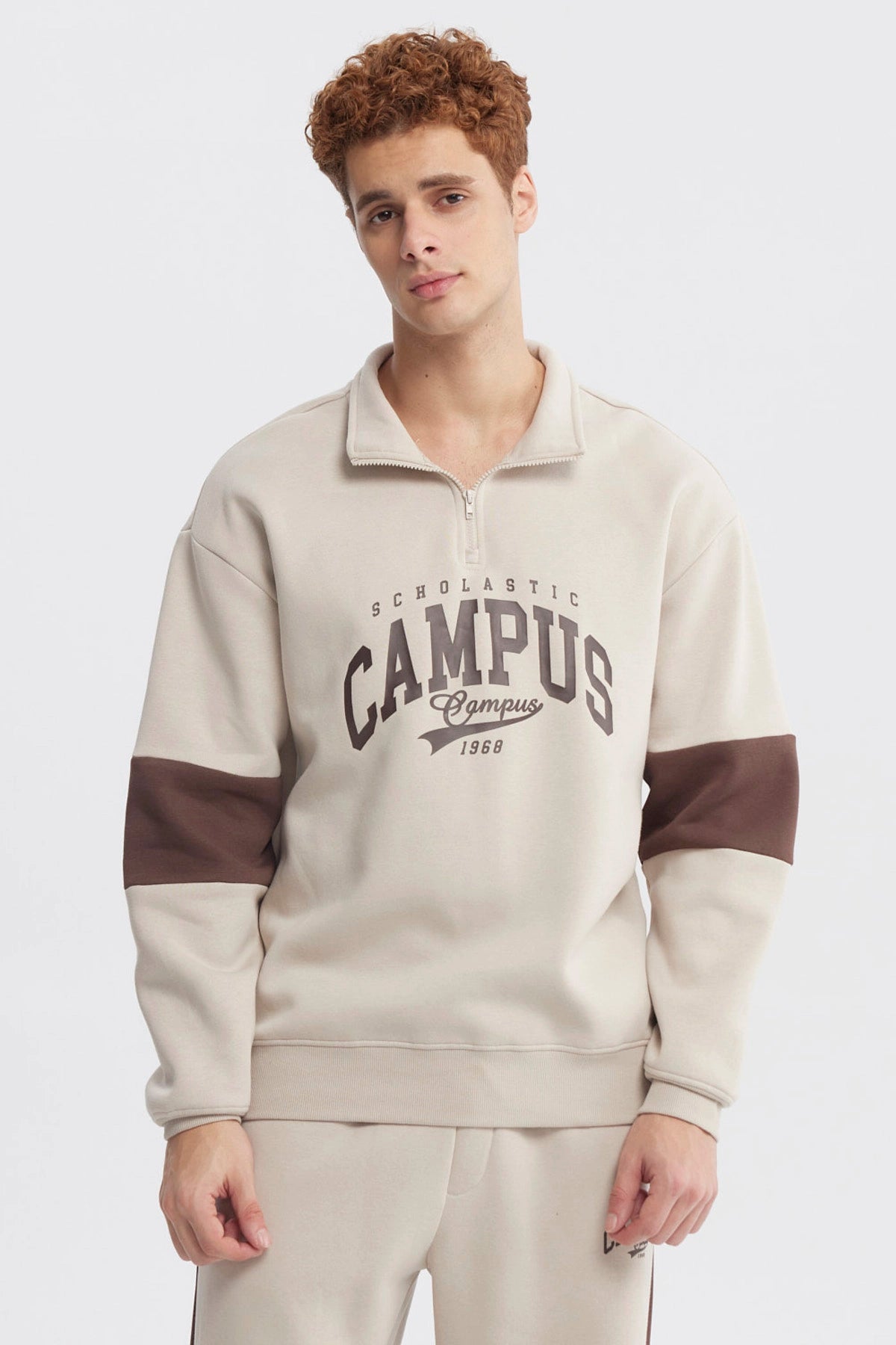 Polerón oversize beige con medio cierre y texto Campus 1968 en el pecho estilo universitario casual y cómodo