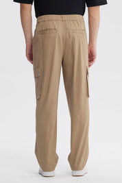 Pantalón cargo hombre kaki con piernas anchas y bolsillos laterales grandes diseño utilitario sin estampa visible